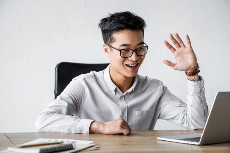 man waving high during an online meeting, advertising company