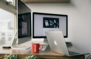 Modern workspace with computers and laptop used by a web development agency in Singapore for website design and development projects.