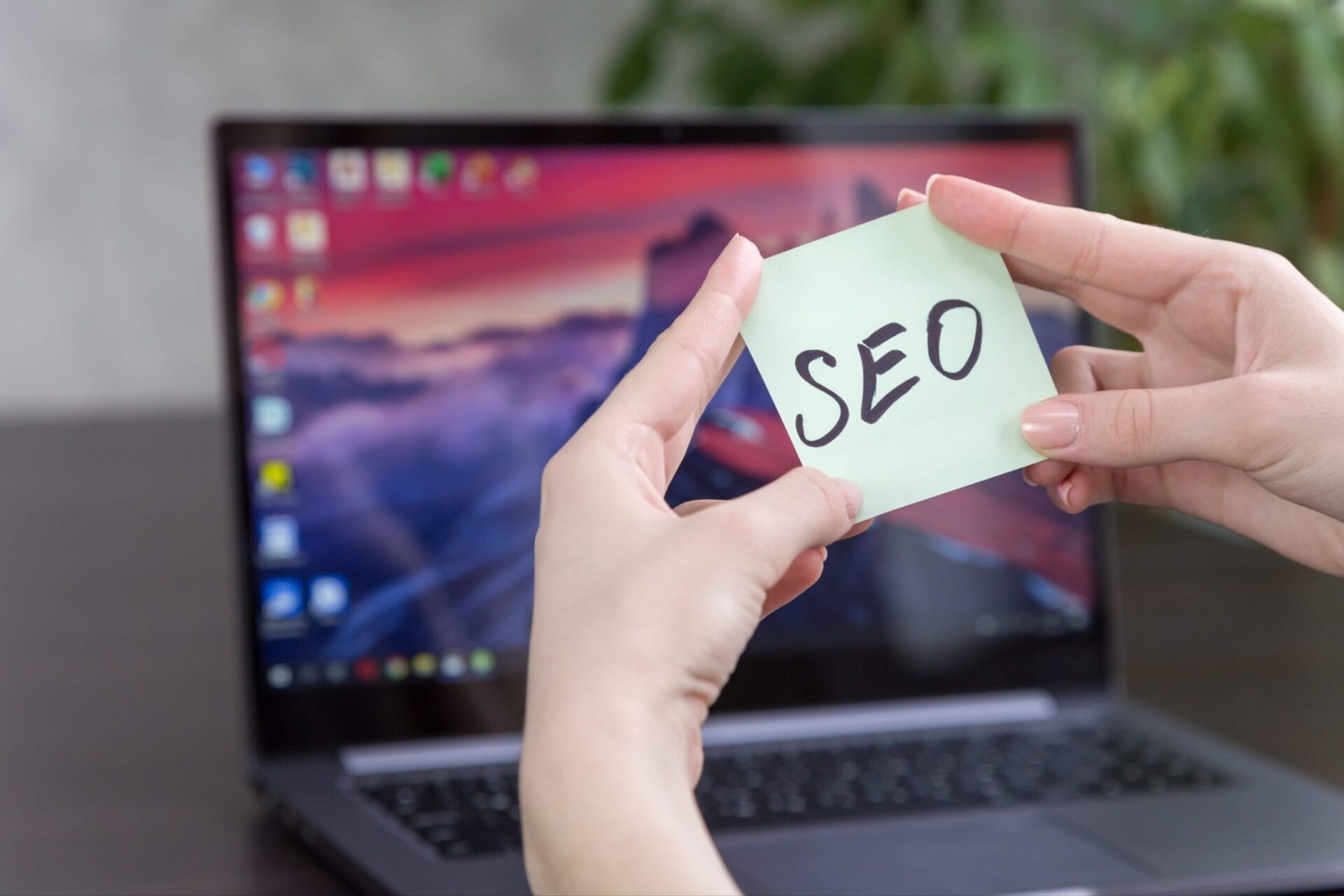 hands holding post it with a sign saying seo